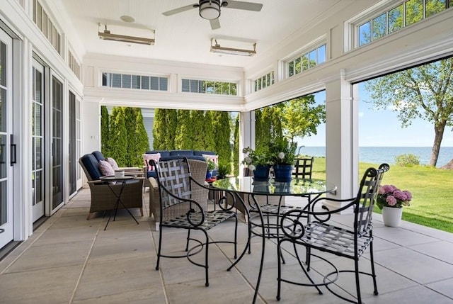 sunroom featuring ceiling fan and a water view