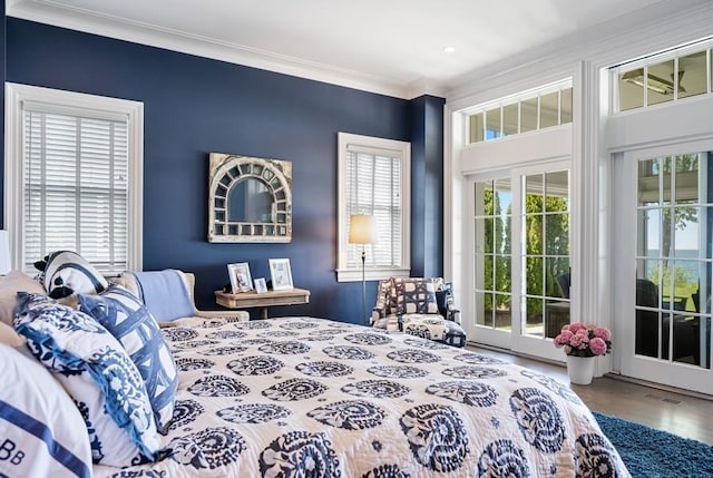 bedroom with ornamental molding, access to outside, and multiple windows