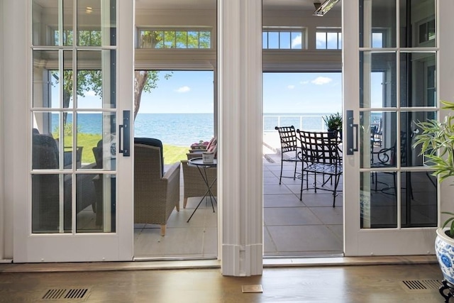 entryway with french doors, a water view, and wood-type flooring