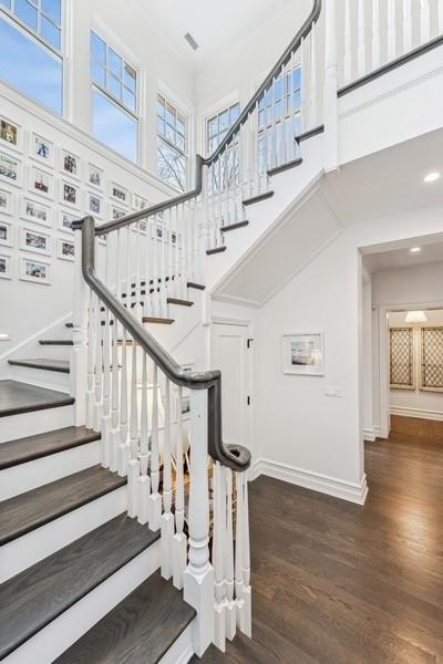 staircase with wood-type flooring and a high ceiling