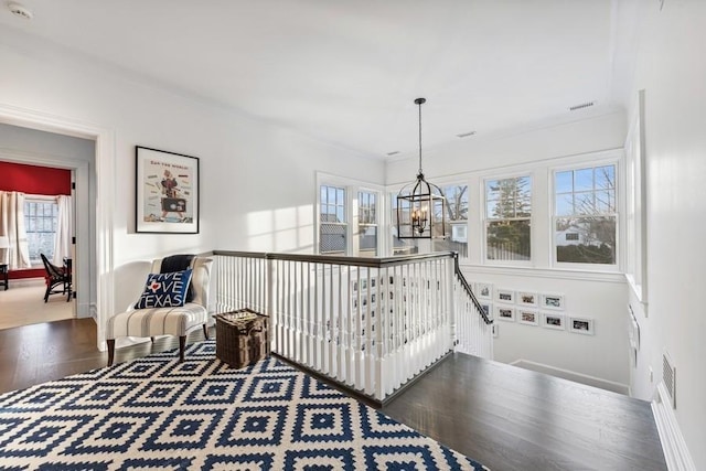 corridor featuring an inviting chandelier and hardwood / wood-style flooring