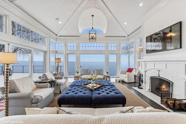 living room featuring high vaulted ceiling, an inviting chandelier, ornamental molding, a water view, and wooden ceiling