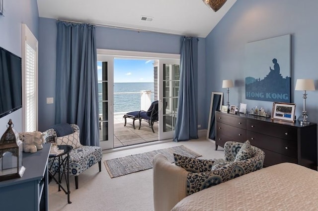 bedroom featuring light colored carpet, access to exterior, a water view, and vaulted ceiling