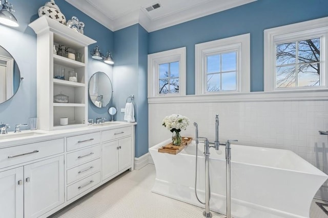 bathroom with crown molding, vanity, and a bathing tub