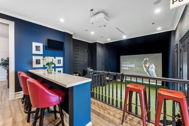 cinema featuring ornamental molding and light hardwood / wood-style flooring