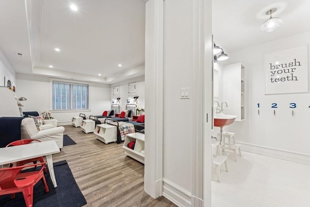 living room with a raised ceiling and sink