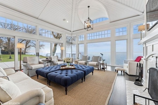 sunroom / solarium with wood ceiling, french doors, a water view, and an inviting chandelier