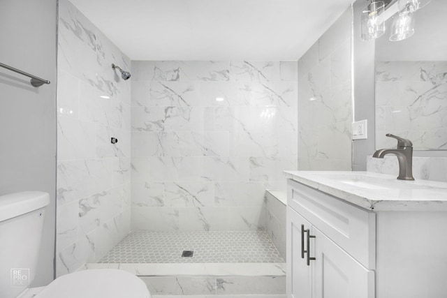 bathroom featuring tiled shower, vanity, and toilet