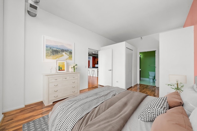 bedroom with ensuite bath and dark hardwood / wood-style flooring