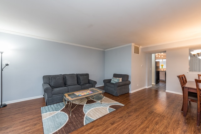 living room featuring dark hardwood / wood-style floors, ornamental molding, and a chandelier