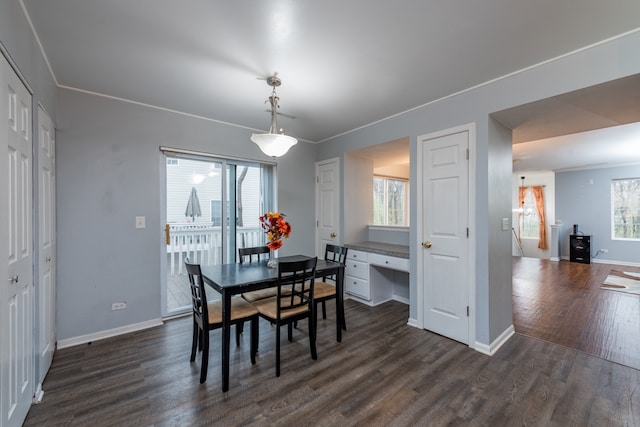 dining room featuring dark hardwood / wood-style floors, a wealth of natural light, and ornamental molding