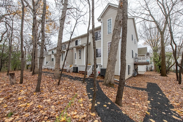 view of side of home with central AC and a wooden deck