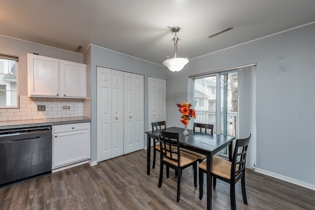 dining space with a healthy amount of sunlight, dark hardwood / wood-style floors, and ornamental molding