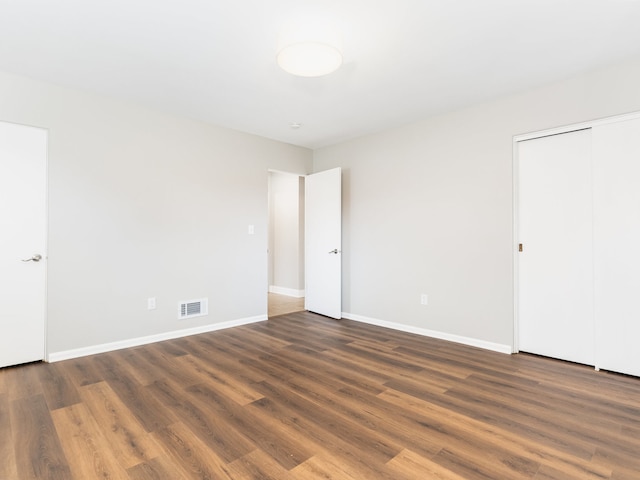 unfurnished room with dark hardwood / wood-style flooring