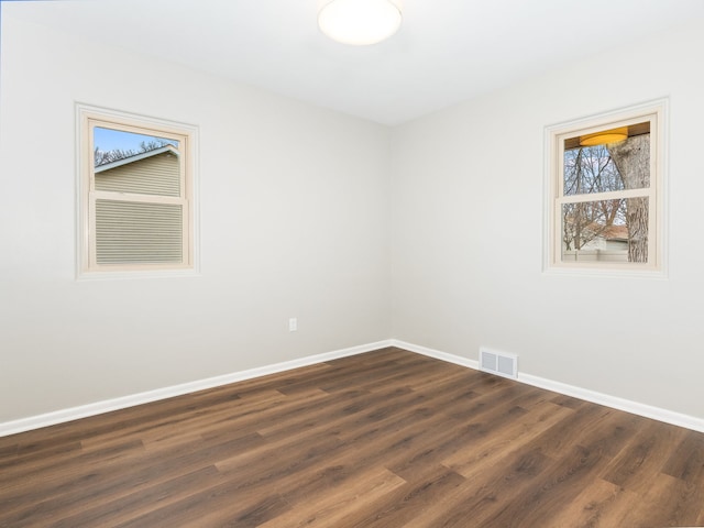 unfurnished room with dark wood-type flooring