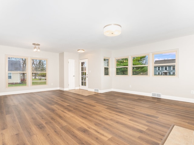 unfurnished living room featuring hardwood / wood-style floors and a notable chandelier