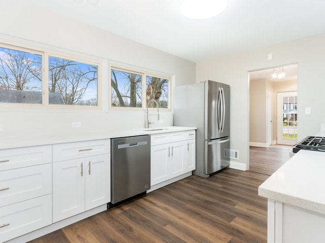 kitchen featuring dark hardwood / wood-style floors, a healthy amount of sunlight, white cabinetry, and appliances with stainless steel finishes