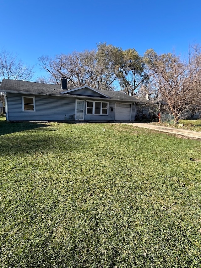 single story home featuring a garage and a front lawn