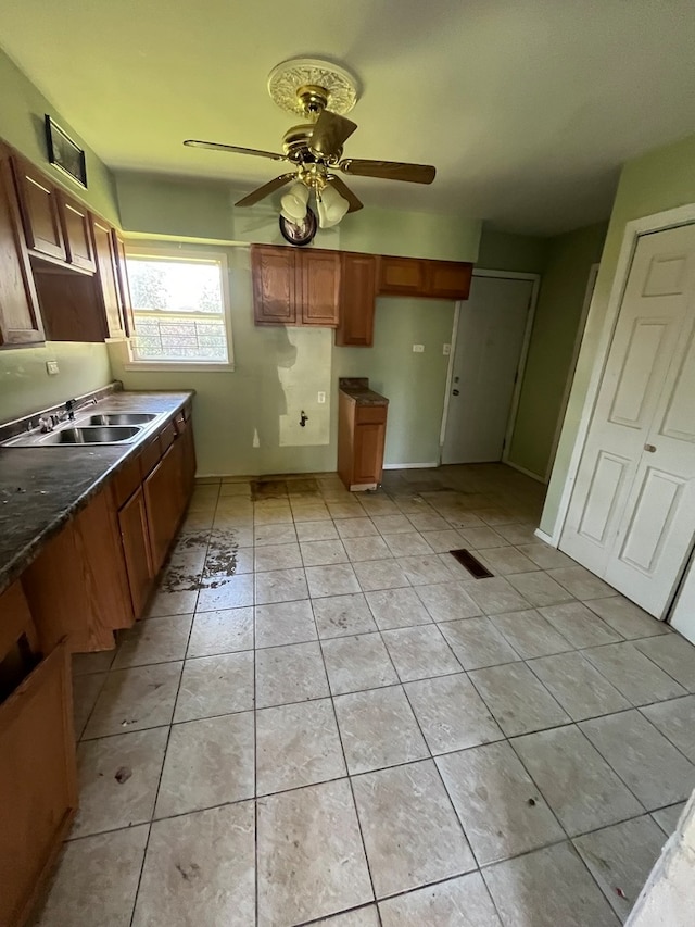 kitchen with ceiling fan, sink, and light tile patterned flooring