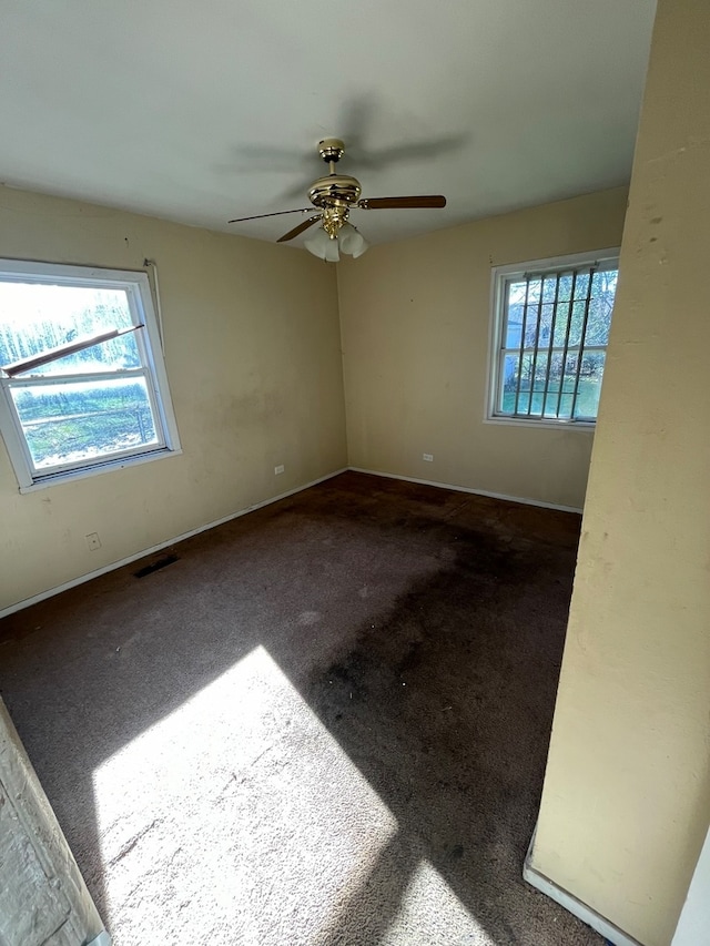 carpeted spare room featuring ceiling fan