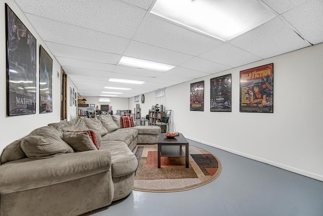 living room with a paneled ceiling and concrete floors