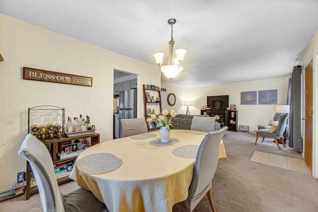 dining space with light colored carpet and an inviting chandelier