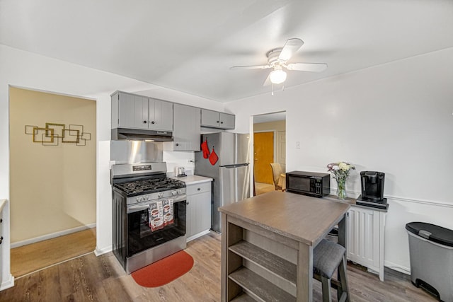 kitchen featuring gray cabinetry, hardwood / wood-style floors, ceiling fan, and appliances with stainless steel finishes