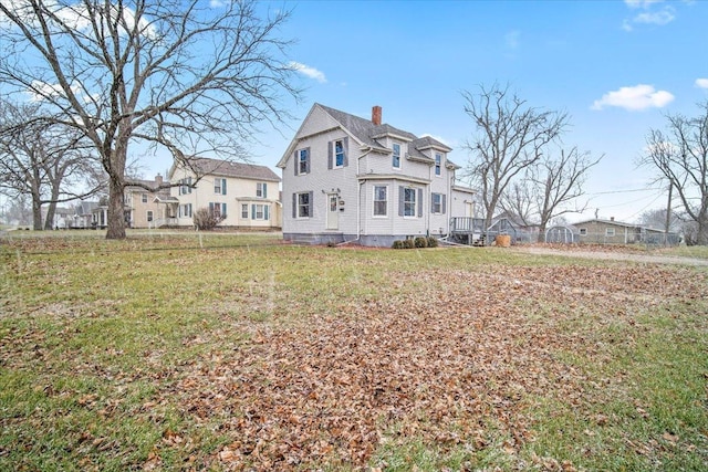 rear view of house featuring a yard