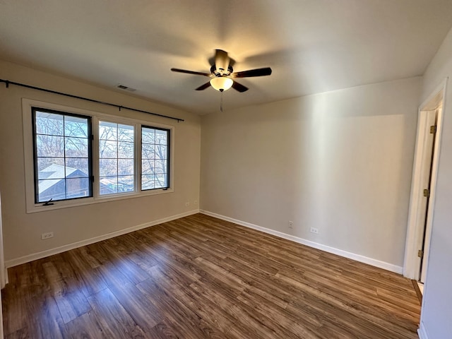 spare room featuring dark hardwood / wood-style floors and ceiling fan