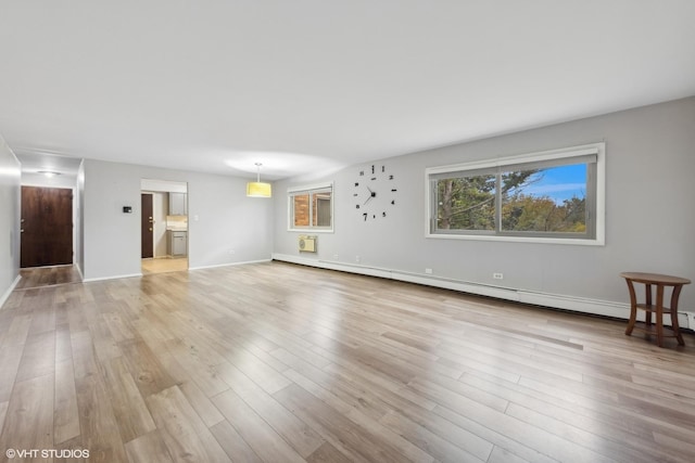 unfurnished living room featuring a baseboard heating unit and light wood-type flooring