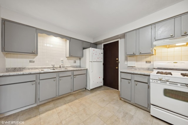 kitchen featuring sink, white appliances, gray cabinets, and decorative backsplash