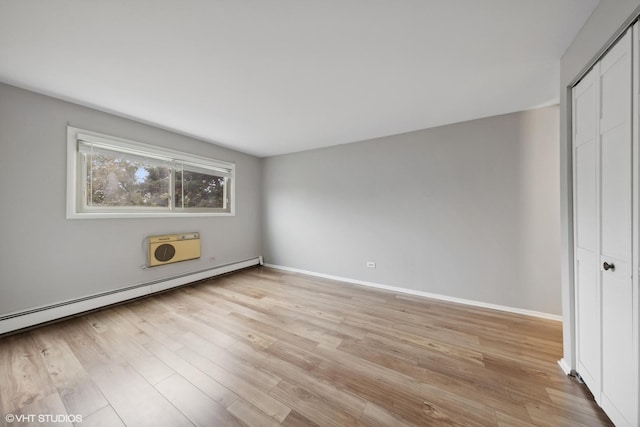 interior space featuring a baseboard heating unit and light wood-type flooring