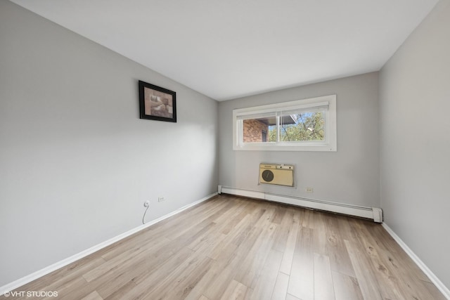 spare room with light wood-type flooring, a wall unit AC, and a baseboard heating unit