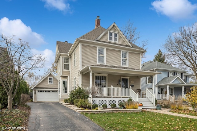 view of front facade featuring a porch, a front lawn, an outdoor structure, and a garage