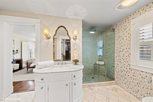 bathroom with hardwood / wood-style flooring, a shower with door, and a healthy amount of sunlight