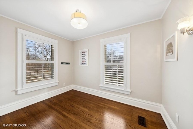 spare room featuring hardwood / wood-style flooring and ornamental molding