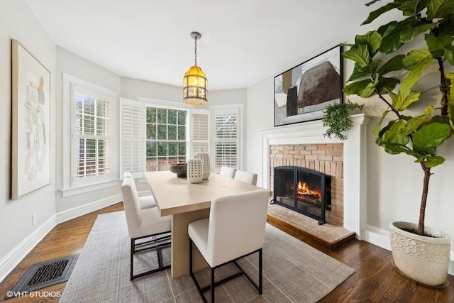 dining room with a fireplace and dark hardwood / wood-style floors