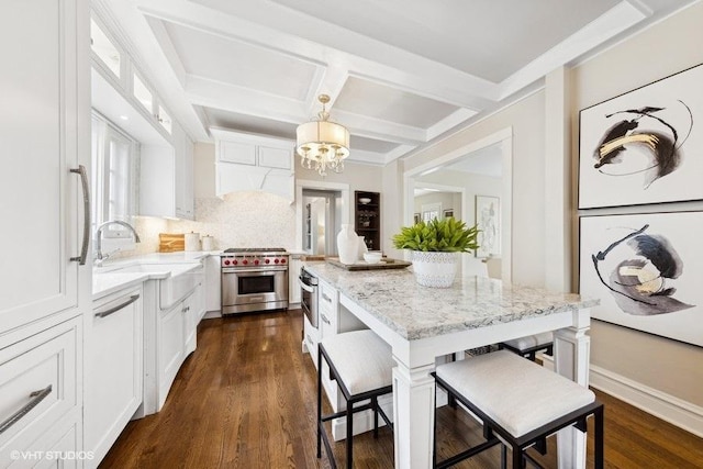 kitchen with decorative light fixtures, white cabinetry, premium stove, dark hardwood / wood-style floors, and a kitchen island