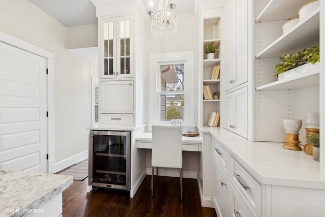 office space featuring dark hardwood / wood-style flooring, built in desk, beverage cooler, and a chandelier