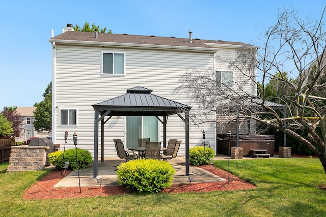 back of house with an outdoor kitchen, a gazebo, a yard, a patio area, and a hot tub