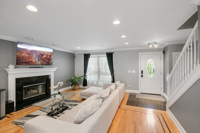 living room featuring a healthy amount of sunlight, wood-type flooring, and crown molding