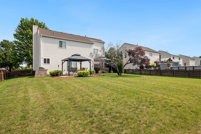 back of property with a gazebo and a lawn