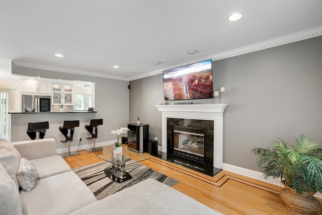 living room with hardwood / wood-style floors and crown molding