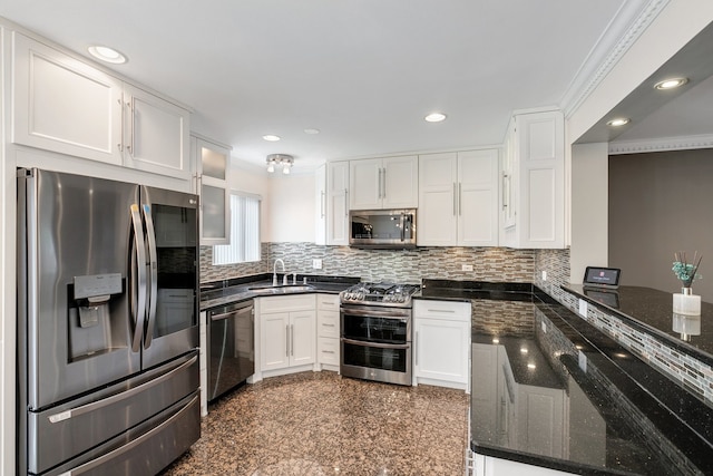 kitchen featuring white cabinets, dark stone countertops, crown molding, and appliances with stainless steel finishes