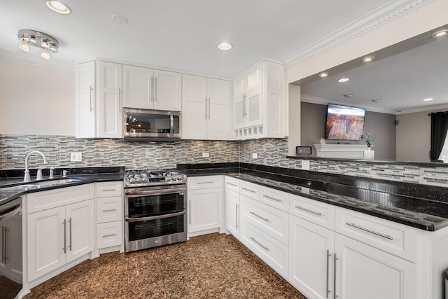 kitchen featuring sink, crown molding, dark stone countertops, white cabinetry, and stainless steel appliances