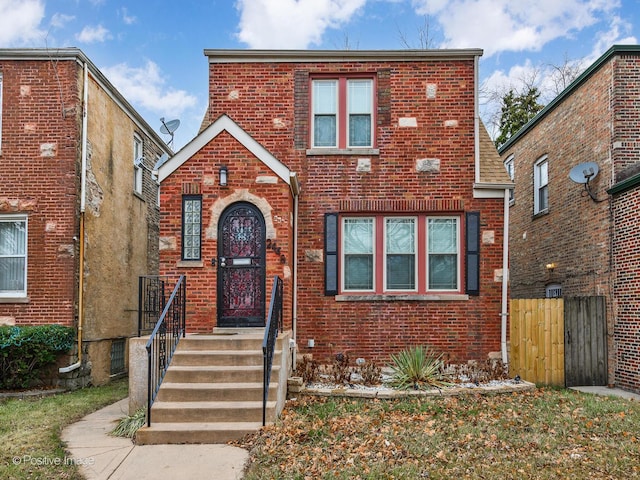 view of front facade featuring brick siding and fence