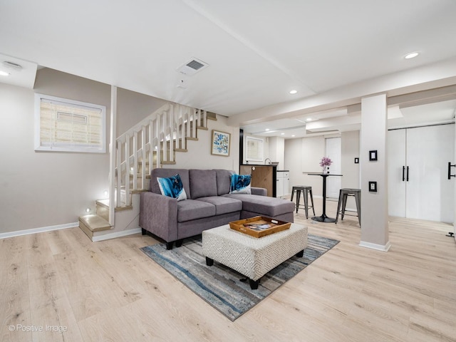 living room with recessed lighting, visible vents, baseboards, stairs, and light wood-style floors