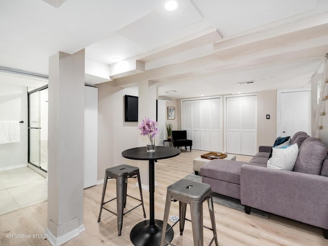 living area featuring light wood finished floors, visible vents, and baseboards