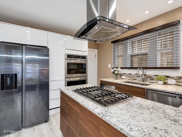 kitchen featuring island exhaust hood, stainless steel appliances, white cabinets, a sink, and modern cabinets