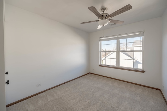 carpeted spare room featuring ceiling fan